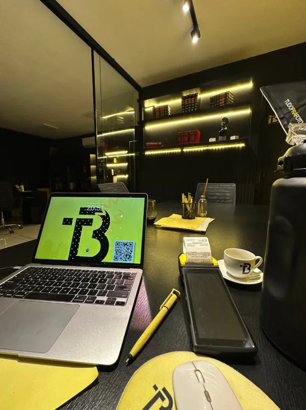 Mesa do advogado à noite, com notebook e café